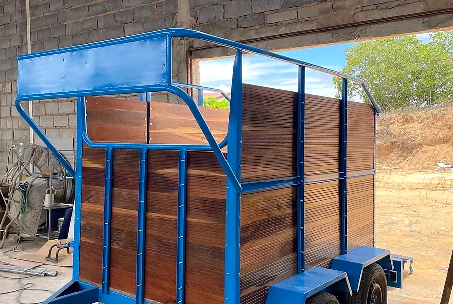 Reboque azul com laterais de madeira para transporte de animais